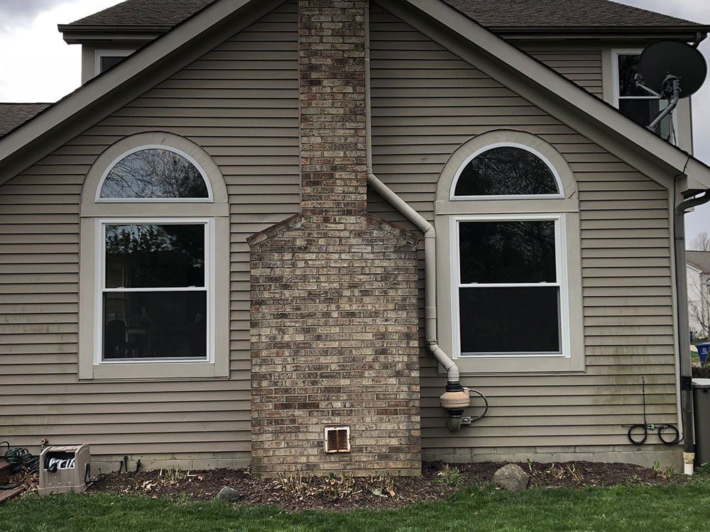 pair of archedwindows on tan house