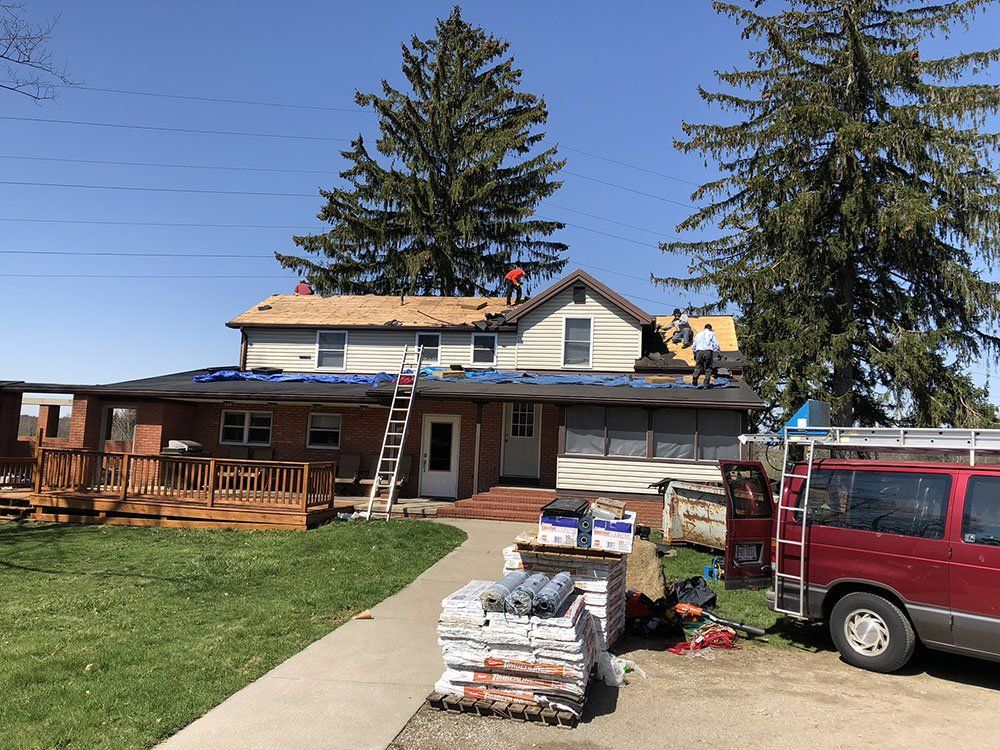 A red van is parked in front of a house that is being remodeled.