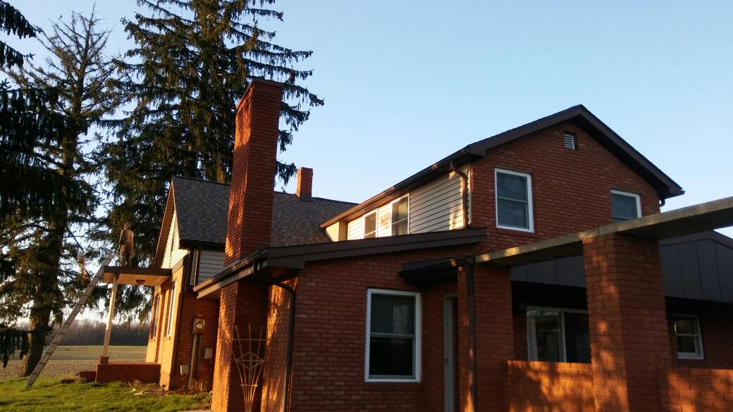 A large brick house with a chimney on the side of it.
