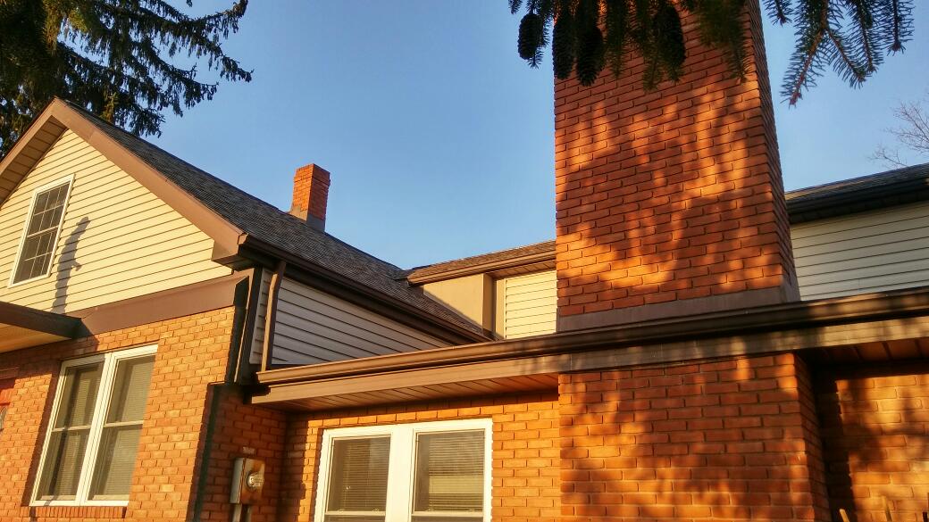 A brick house with a chimney on the side of it.