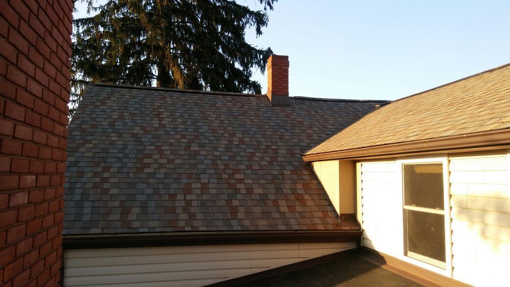 A house with a brick wall and a chimney on the roof