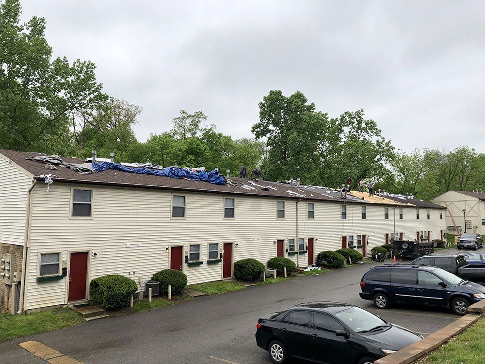 A row of apartment buildings with cars parked in front of them.