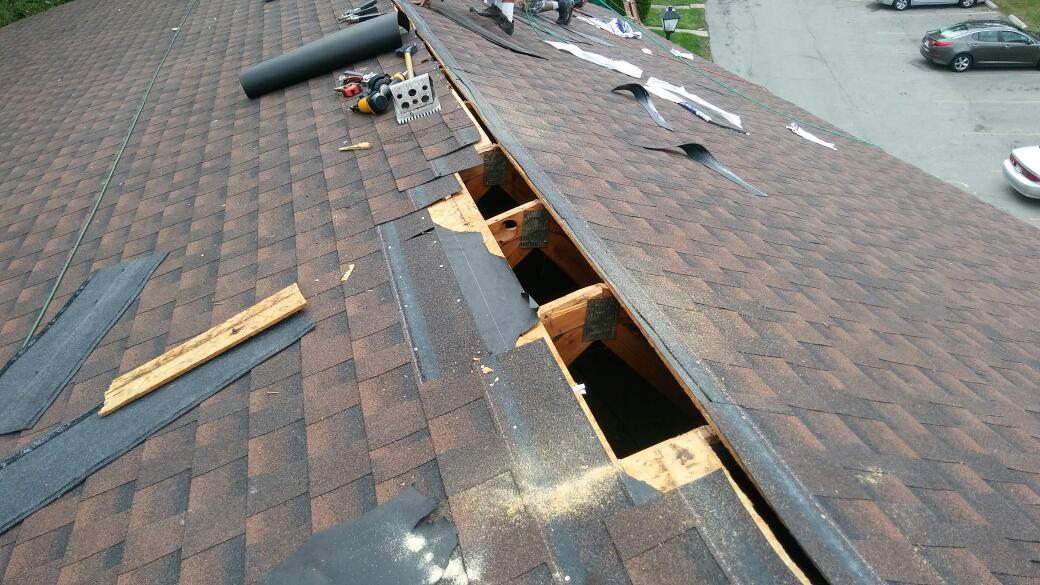 A roof with a hole in it is being repaired.