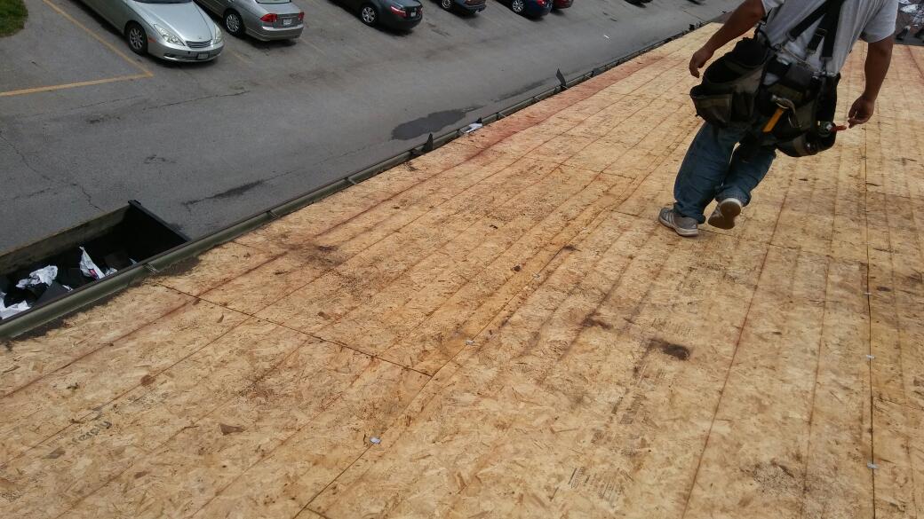 A man is walking on top of a wooden roof.