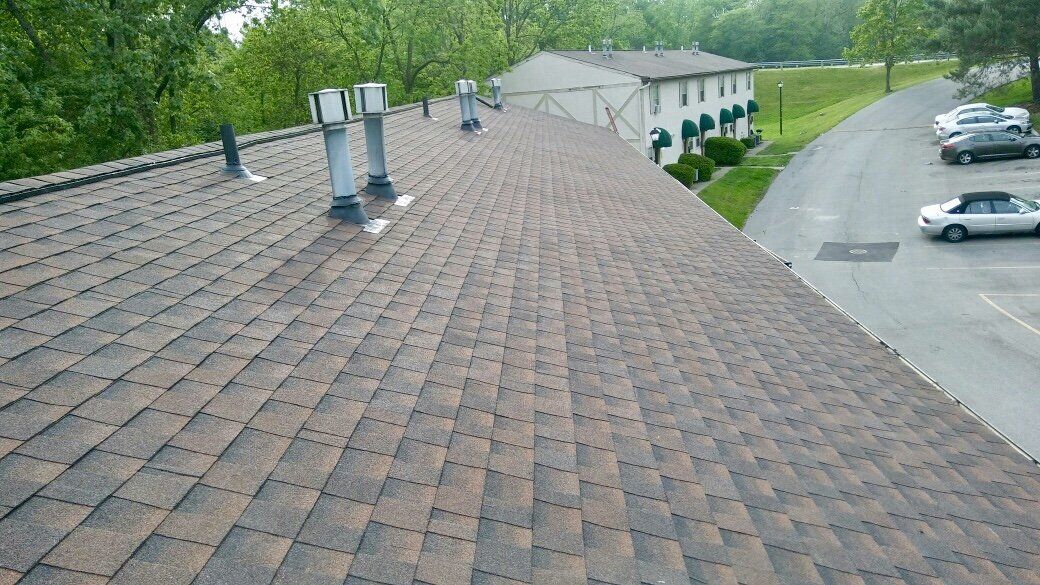 A car is parked on the side of the road next to a roof.