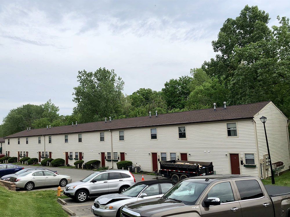 A row of houses with cars parked in front of them