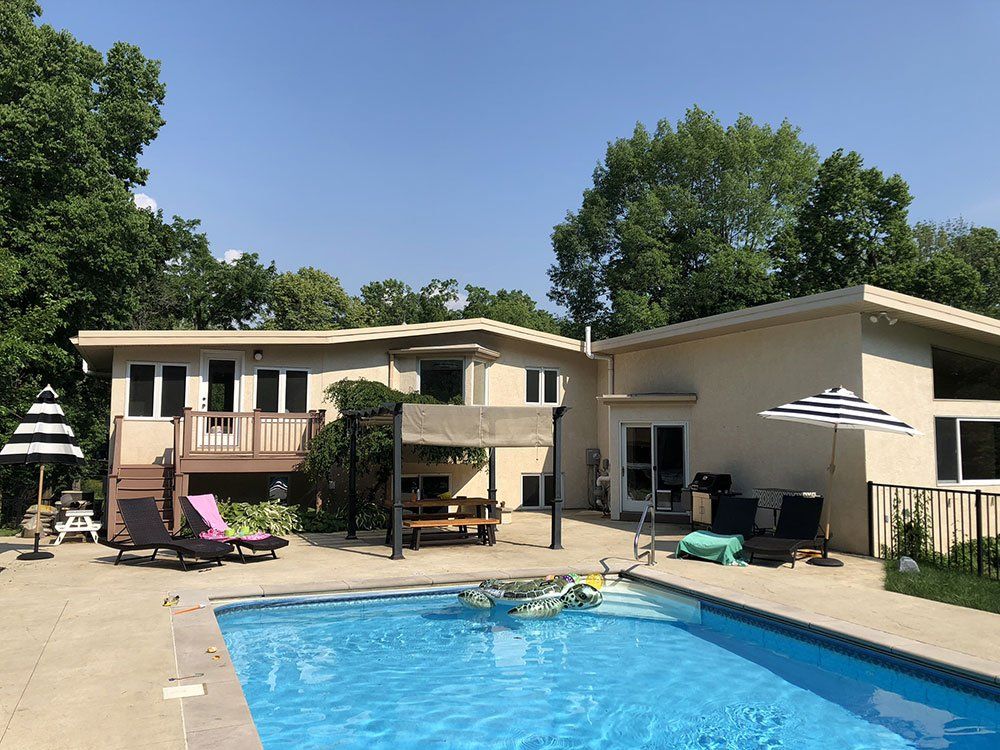 A large house with a large swimming pool in front of it.