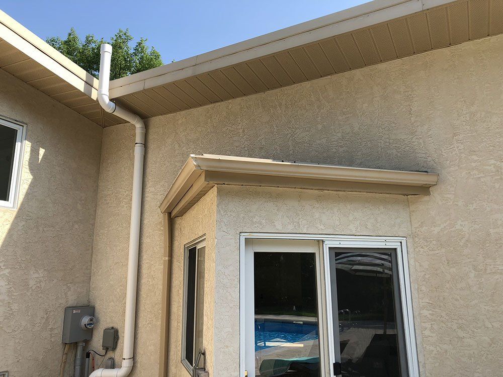 A house with a sliding glass door and a gutter on the side of it.