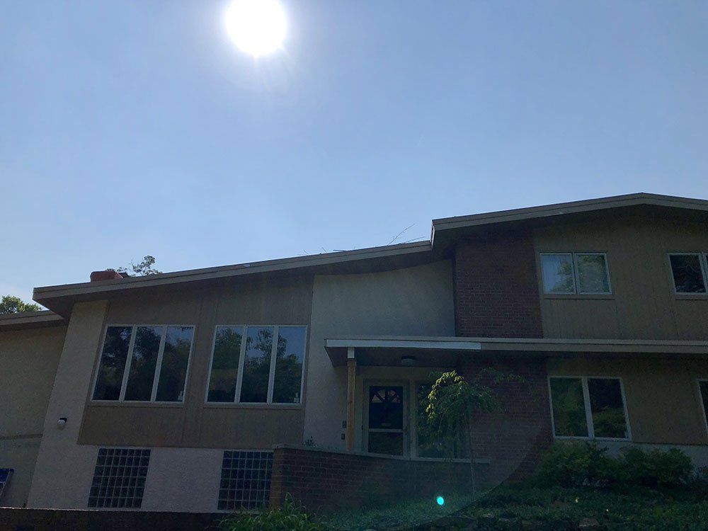 A large house with a lot of windows and a blue sky in the background.