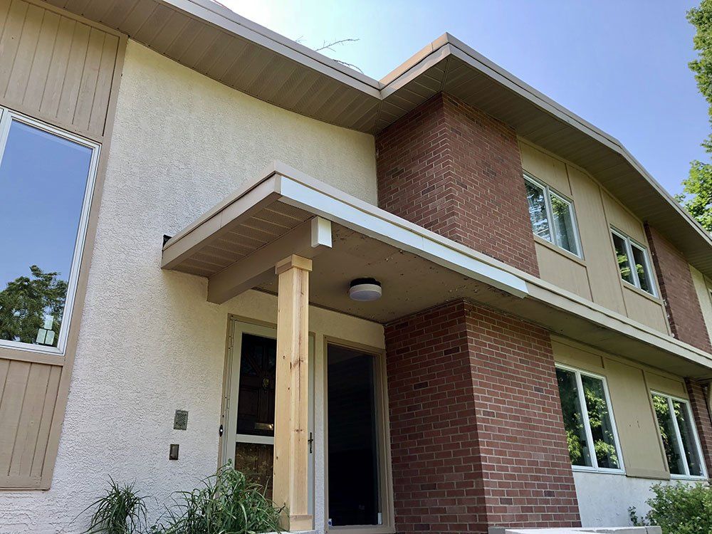 A large house with a porch and a brick facade