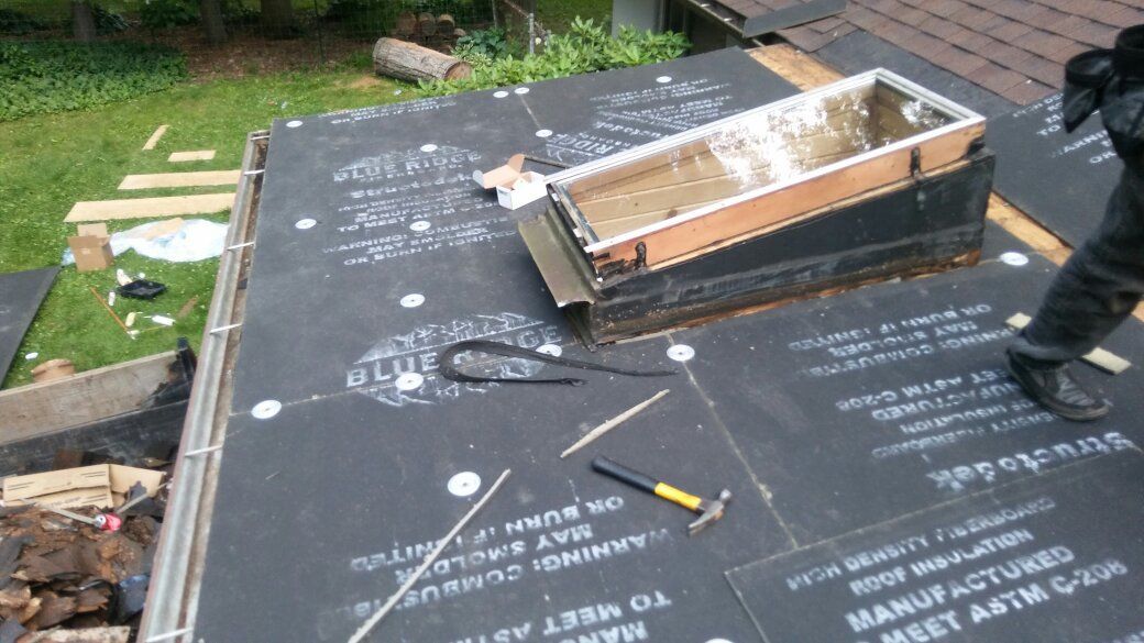 A man is working on a roof with a box on top of it.