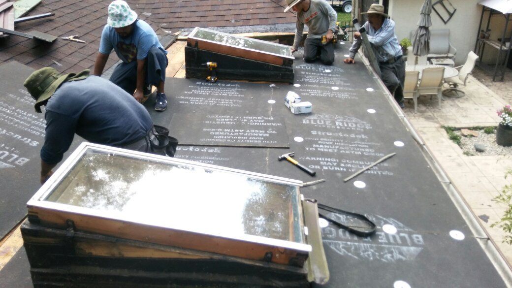 A group of men are working on a roof