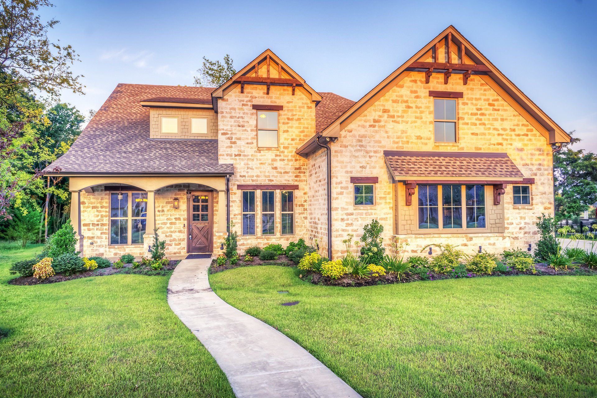 A large brick house with a concrete walkway leading to it Dallas, TX.