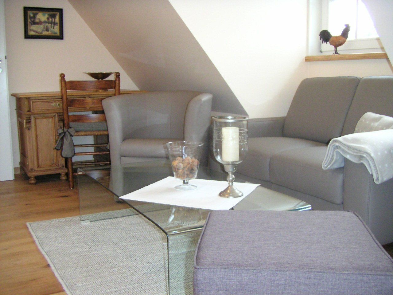 Een woonkamer met een bank en twee stoelen