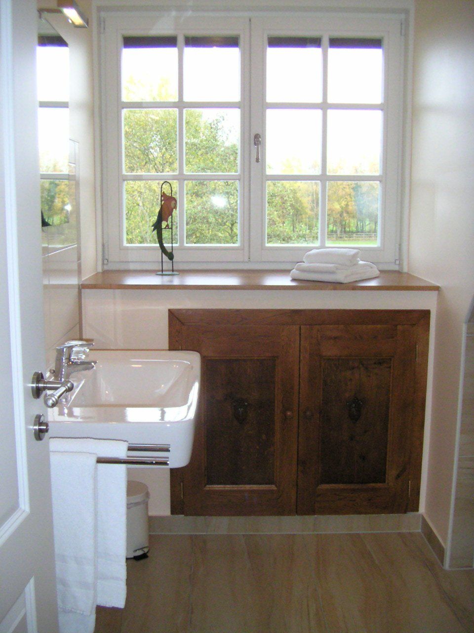 Een badkamer met een wastafel en een raam