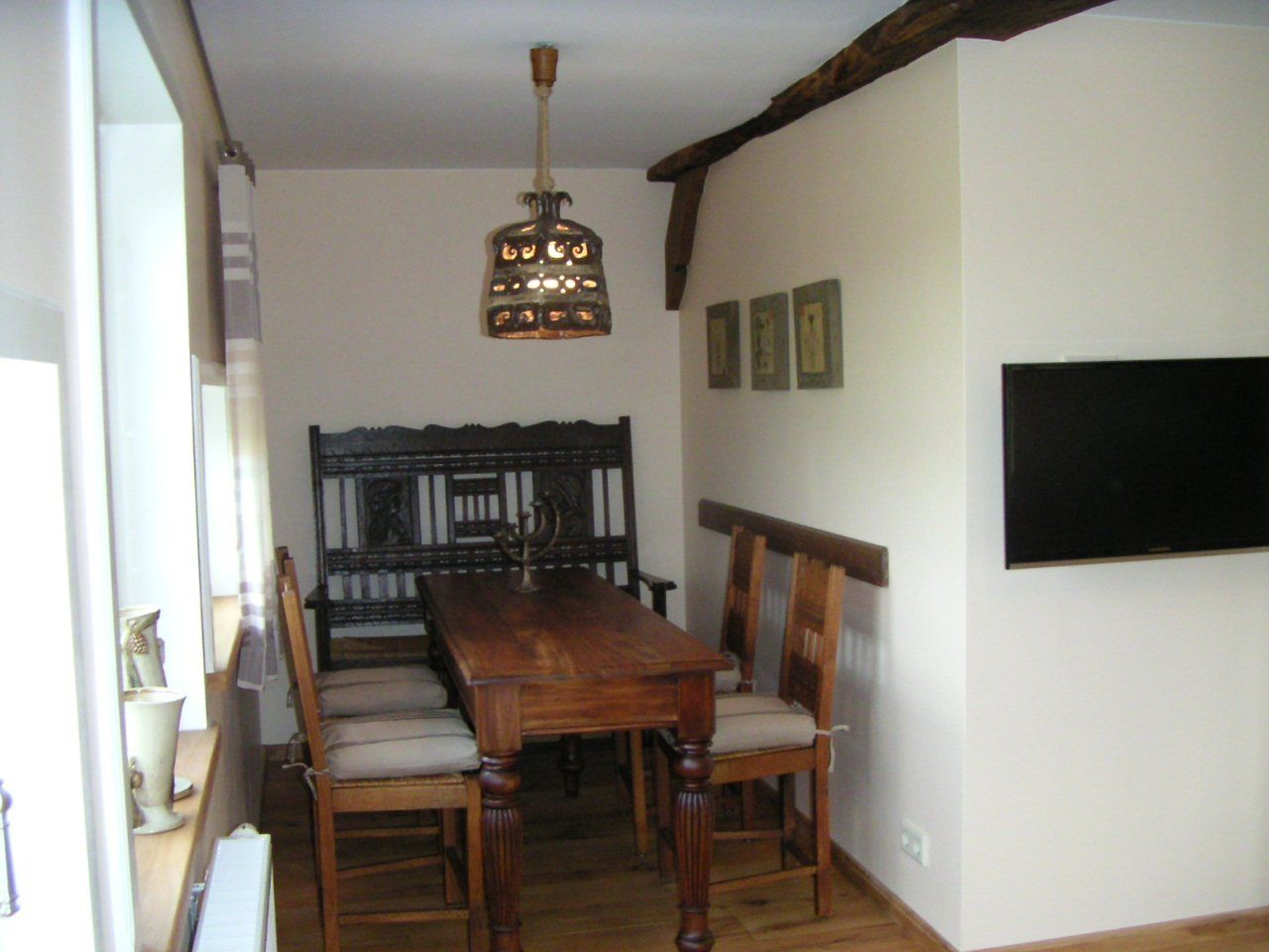 Een eetkamer met een houten tafel en stoelen