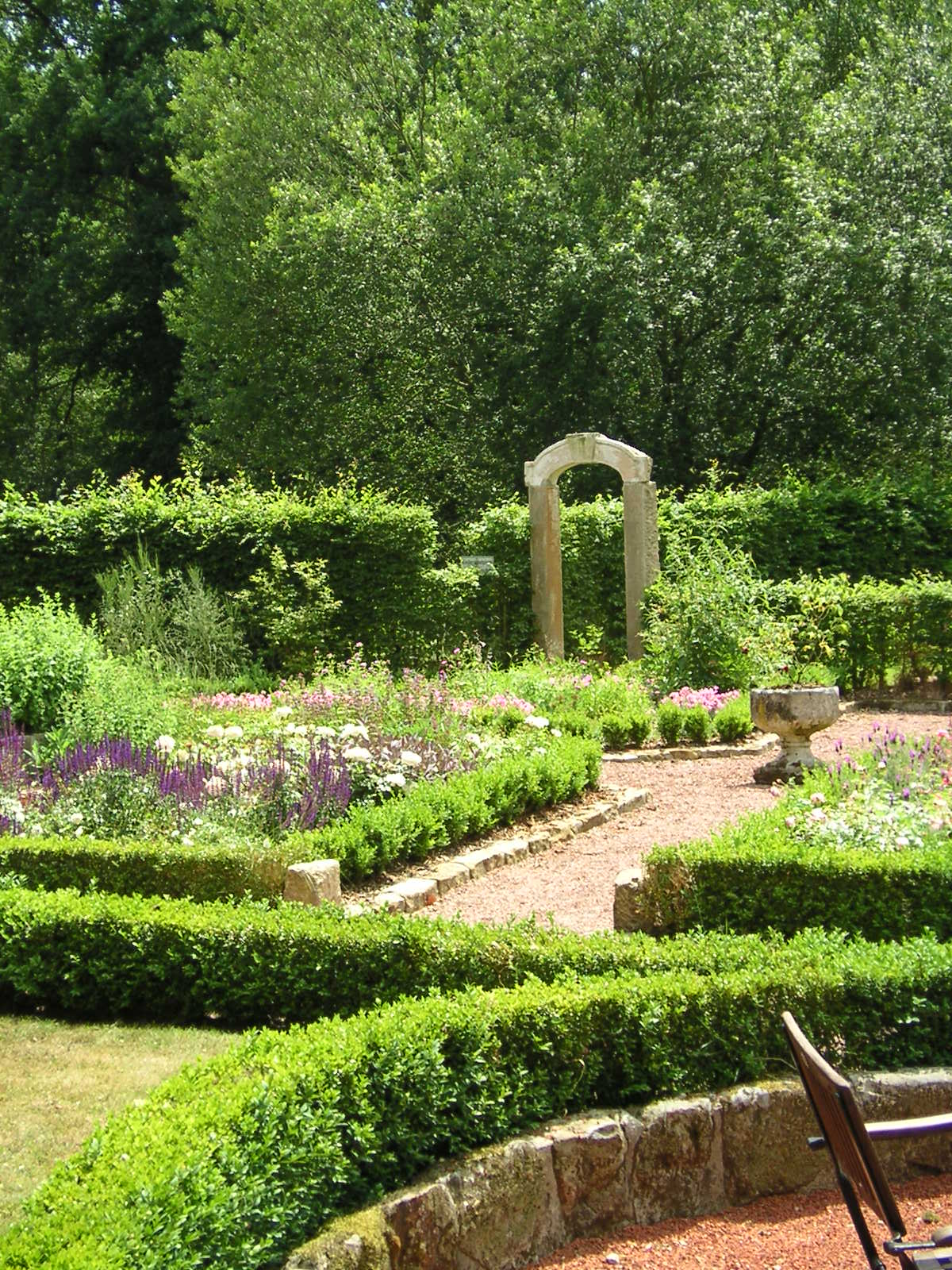 Een tuin met een stenen boog in het midden