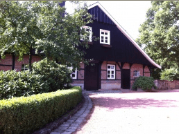 Een bakstenen huis met een zwart dak en witte ramen