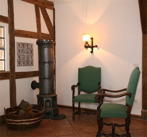 Een kamer met twee stoelen en een kachel erin