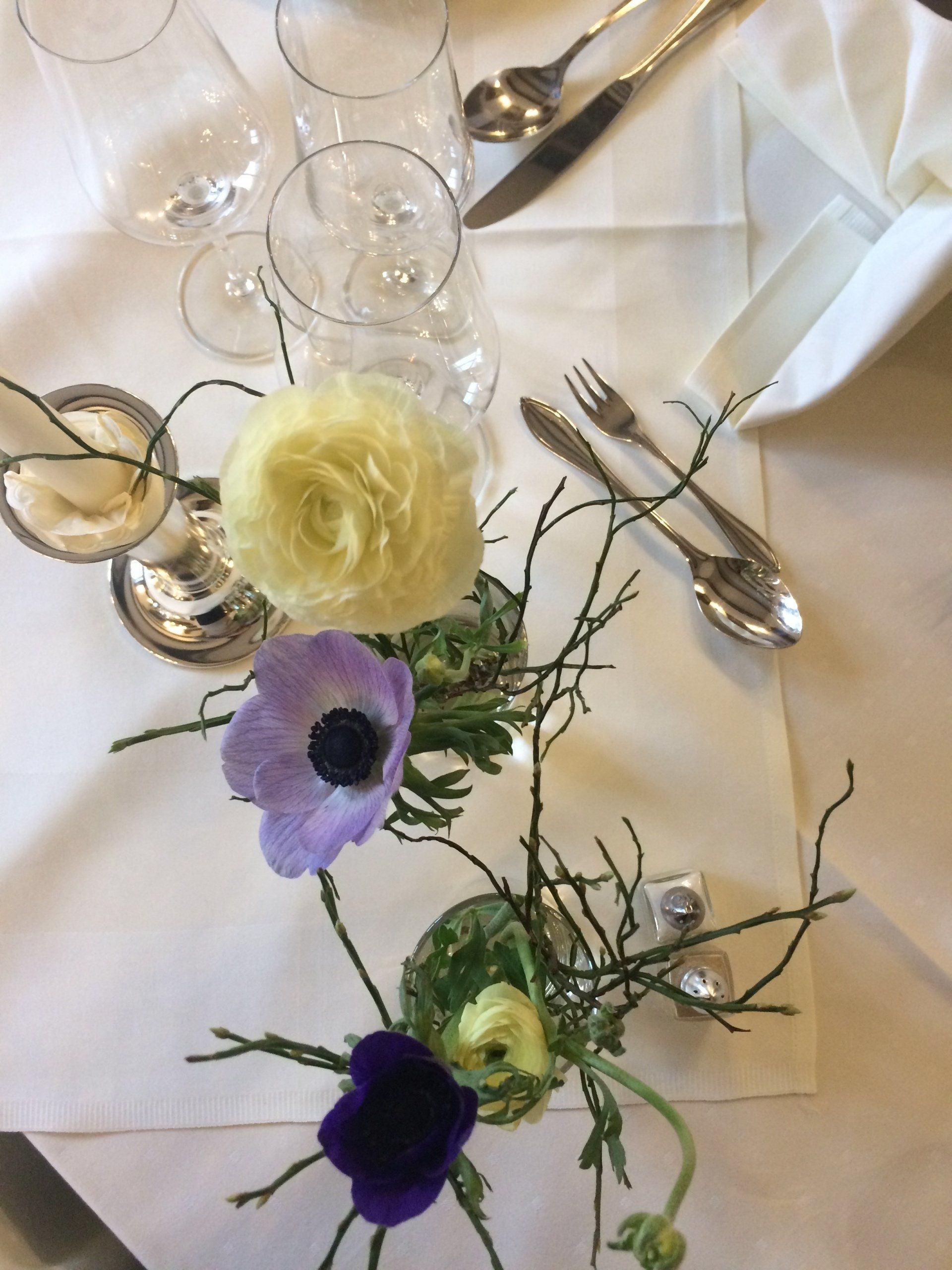 Ein Tisch mit Blumen und Weingläsern darauf