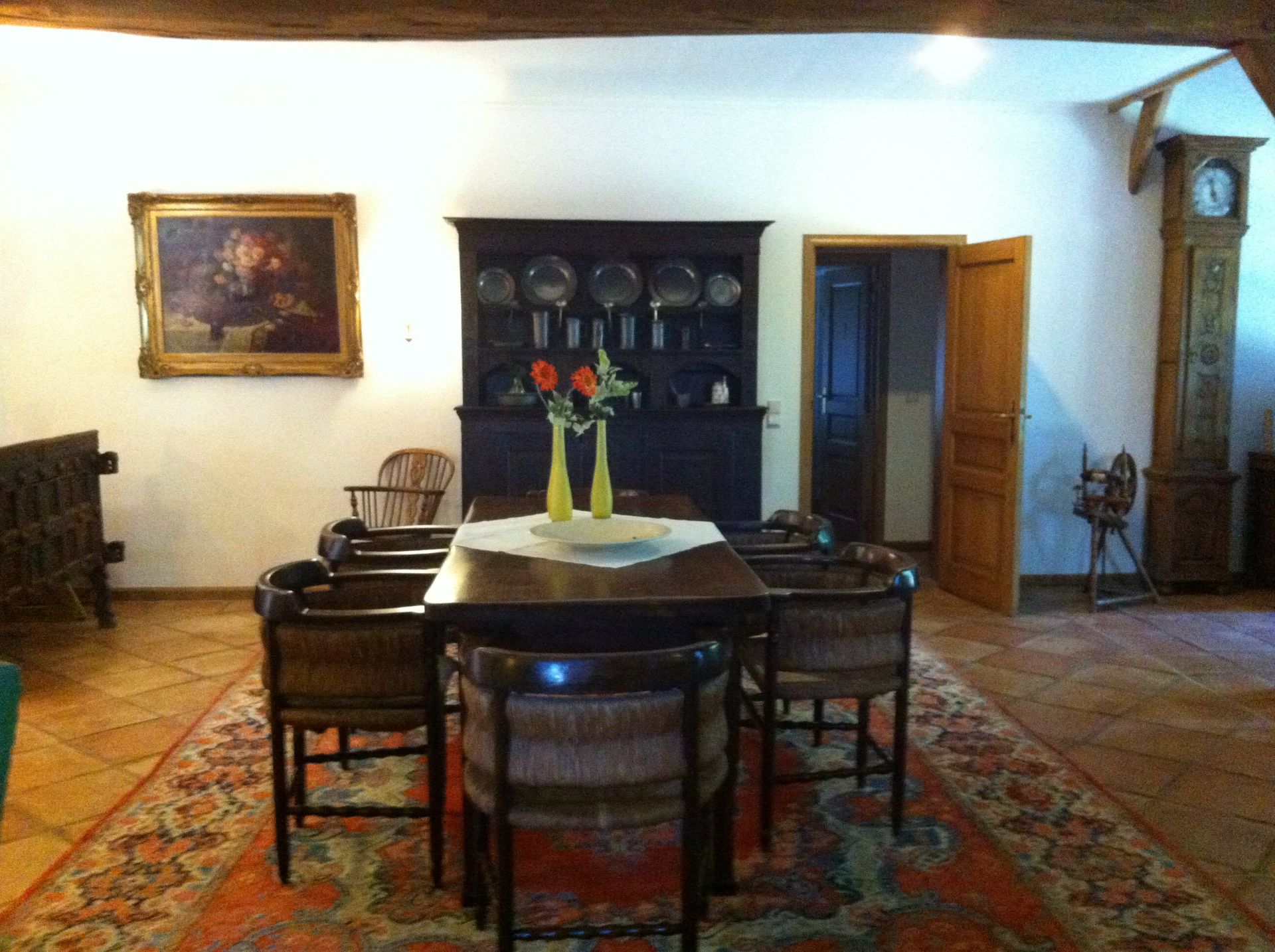 Een eetkamer met een tafel, stoelen en een kleed