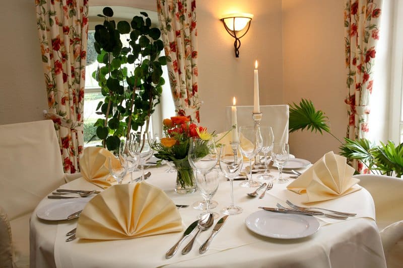 Ein für eine Dinnerparty gedeckter Tisch mit Tellern, Besteck und Kerzen