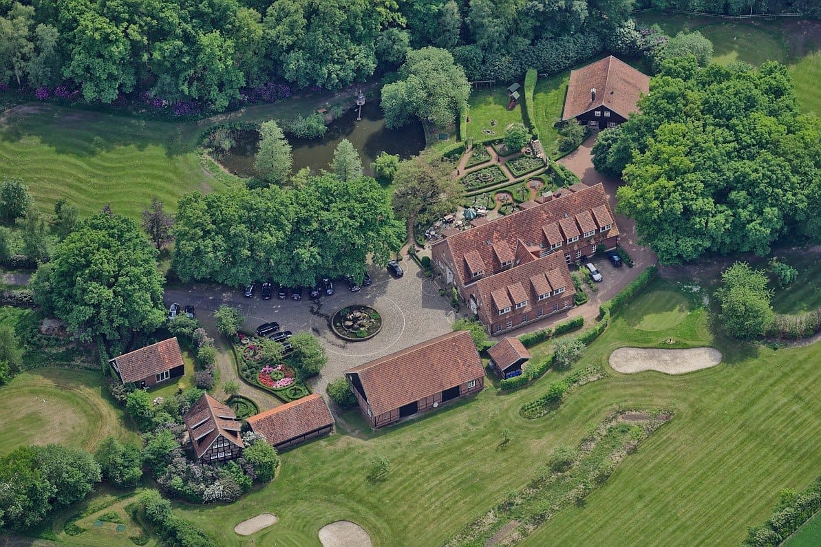 Eine Luftaufnahme eines großen Hauses, umgeben von Bäumen und Gras.