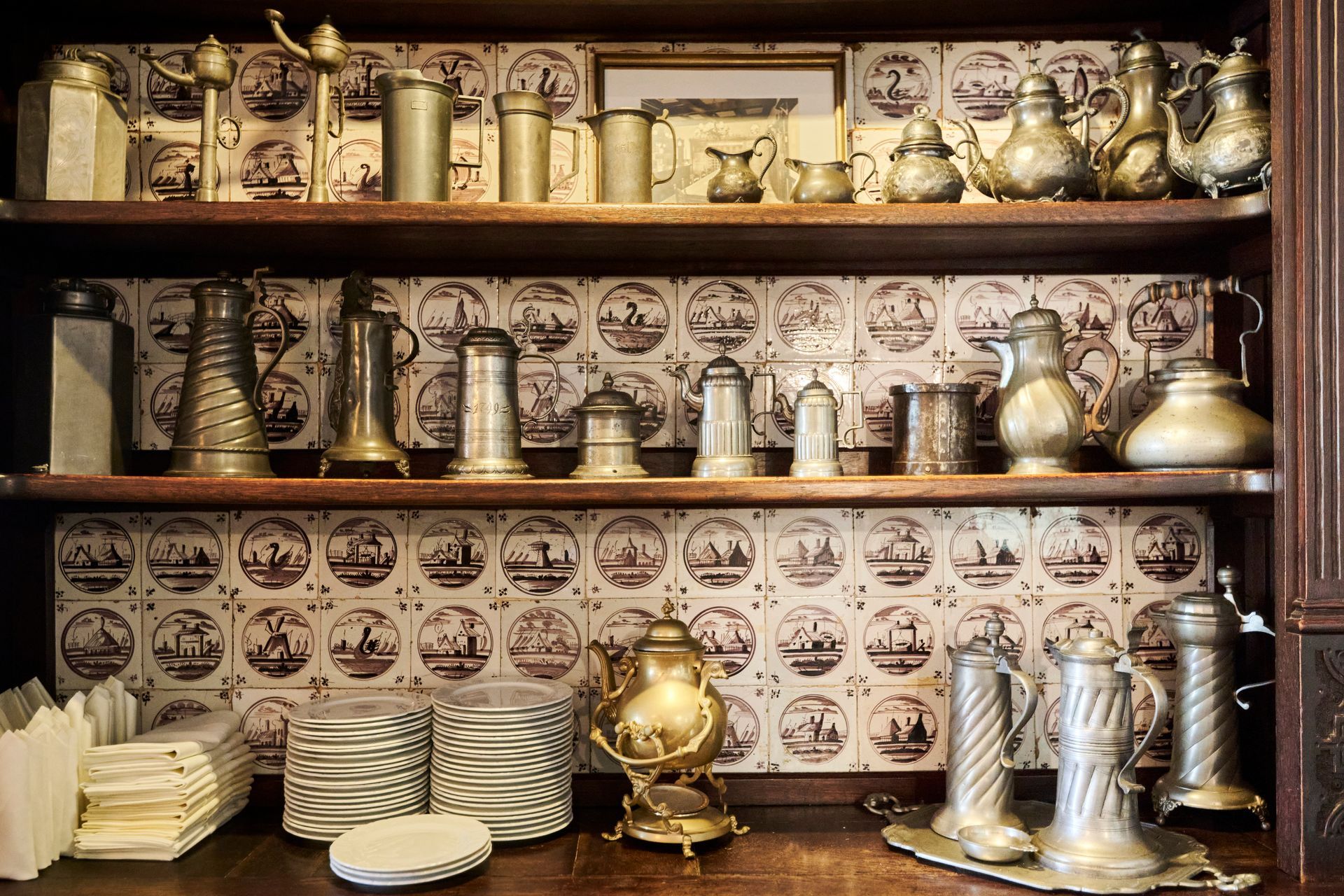 Ein Regal voller antikem Silberbesteck und Tellern.
