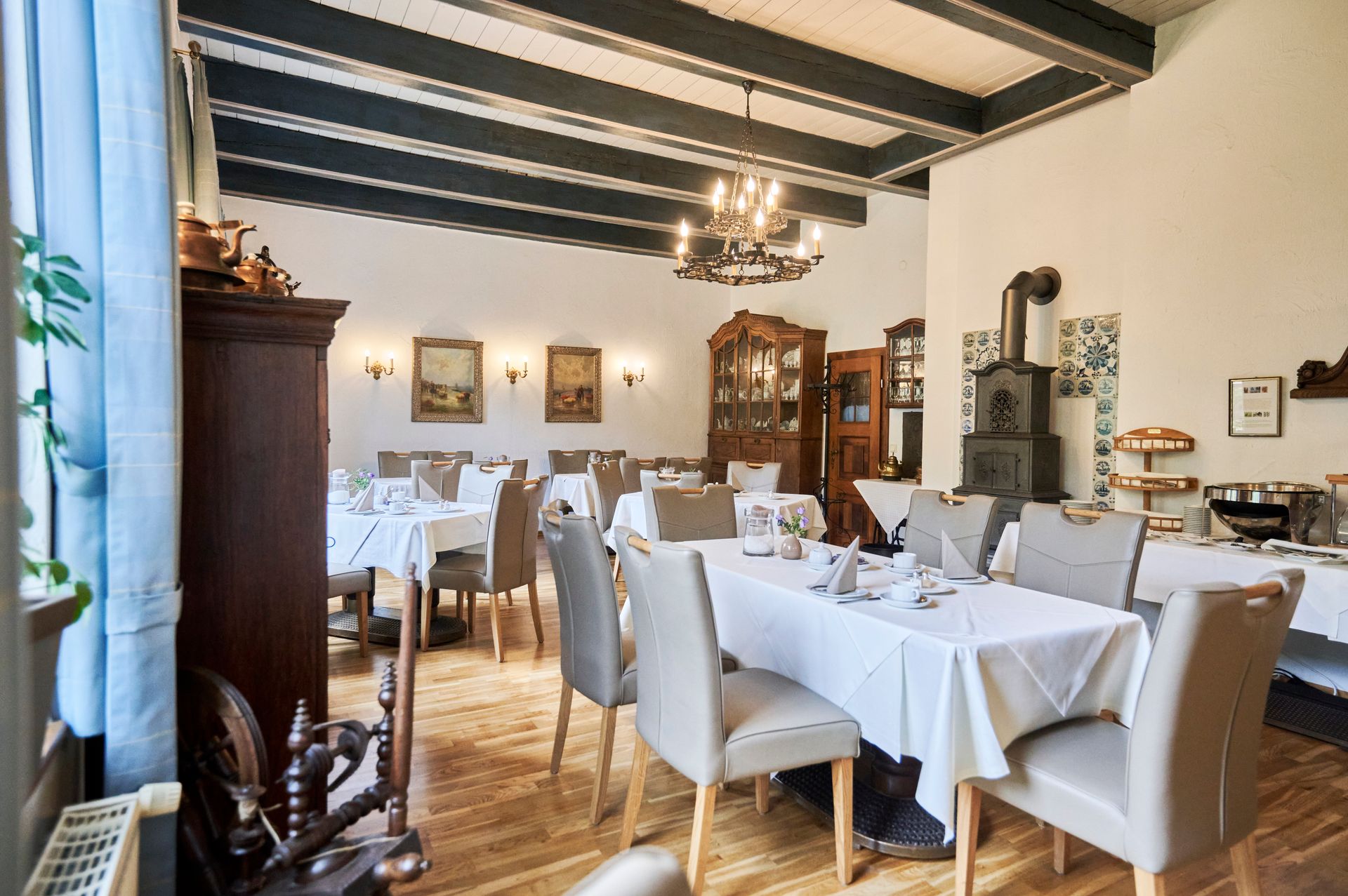 Ein großes Esszimmer mit Tischen und Stühlen und einem Kronleuchter.