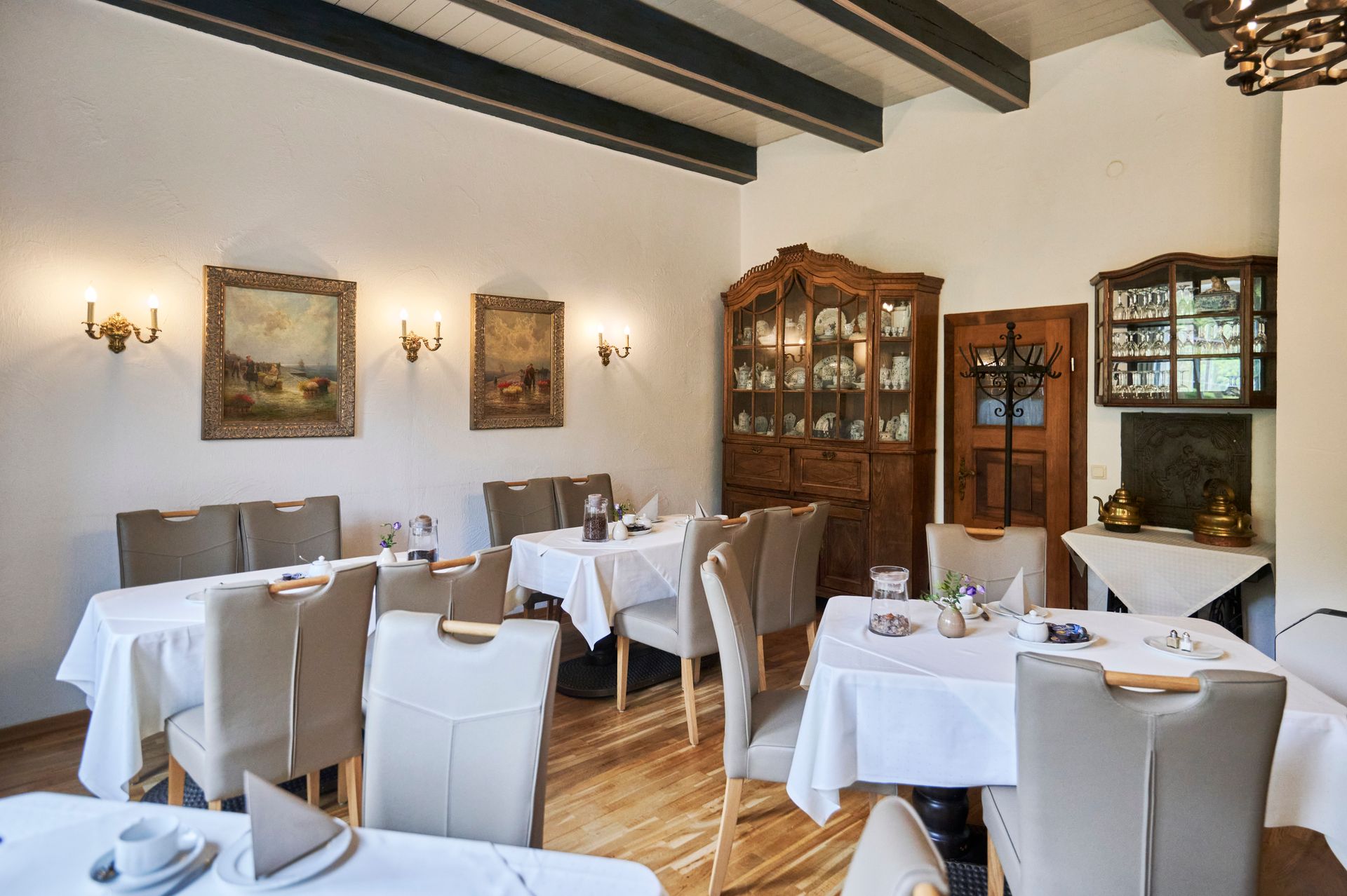 Ein Esszimmer mit Tischen und Stühlen und einer Anrichte.