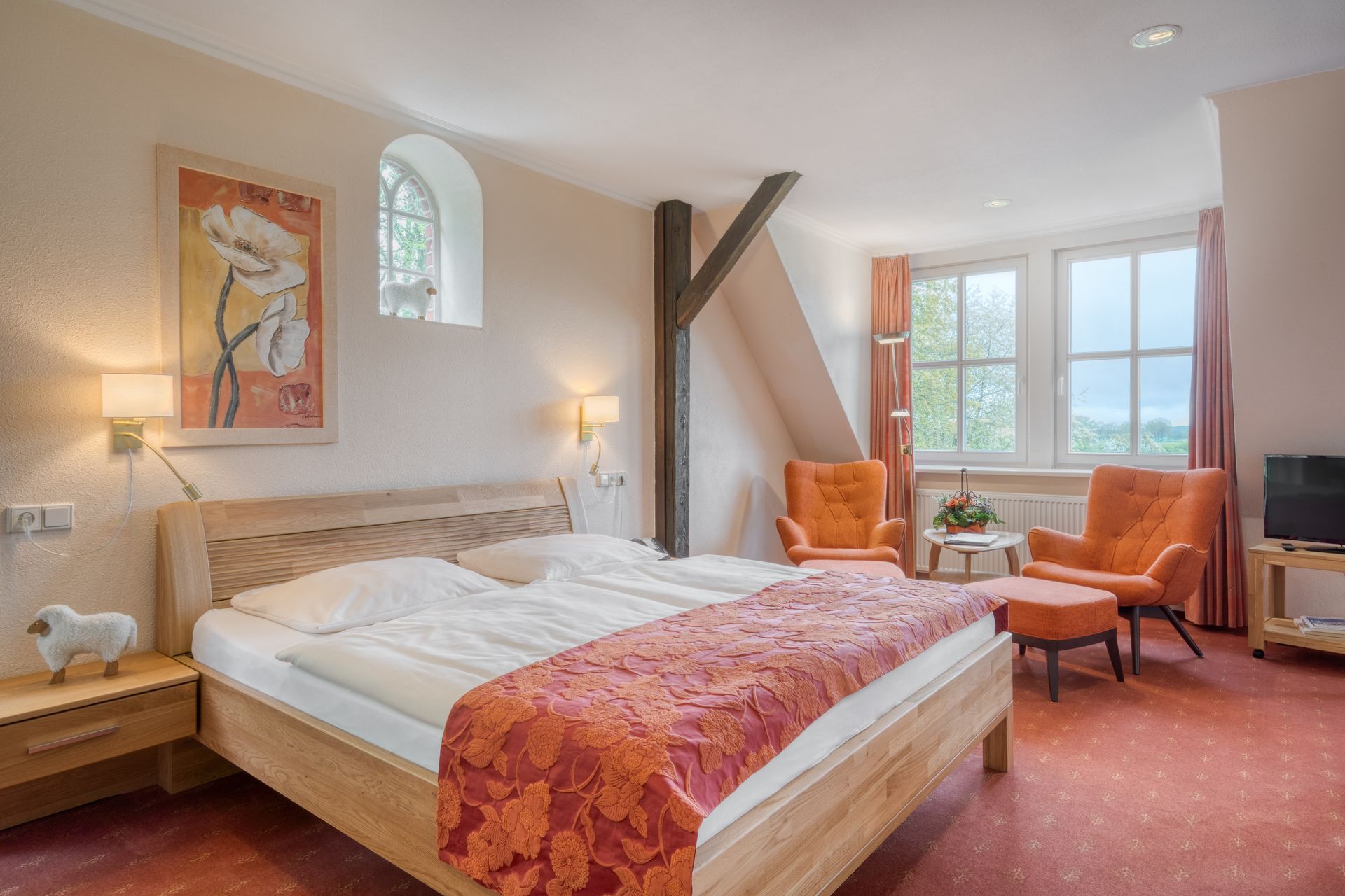 Ein Hotelzimmer mit einem Bett, Stühlen und einem Fernseher.