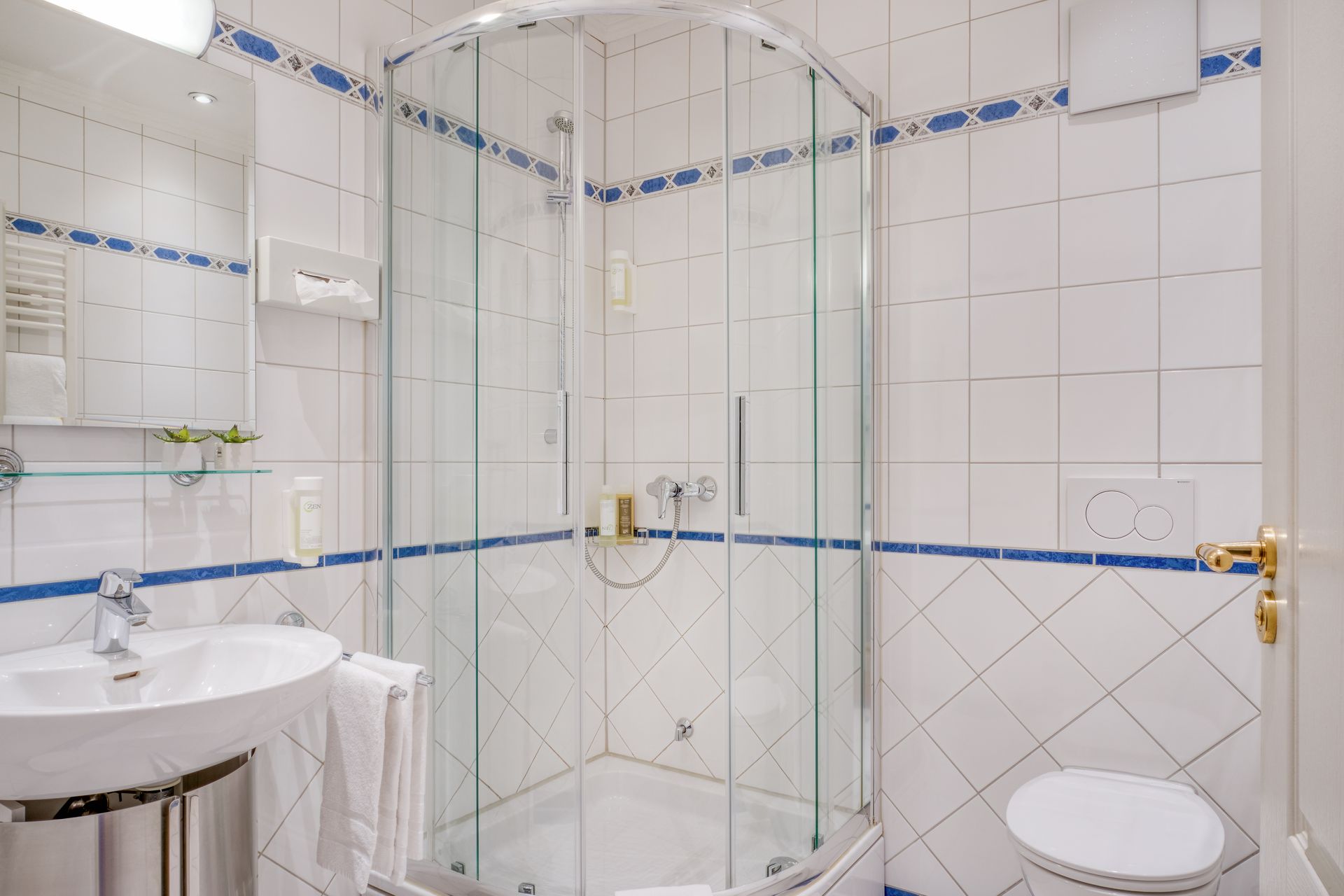 Ein Badezimmer mit Waschbecken, Toilette, Dusche und Spiegel.