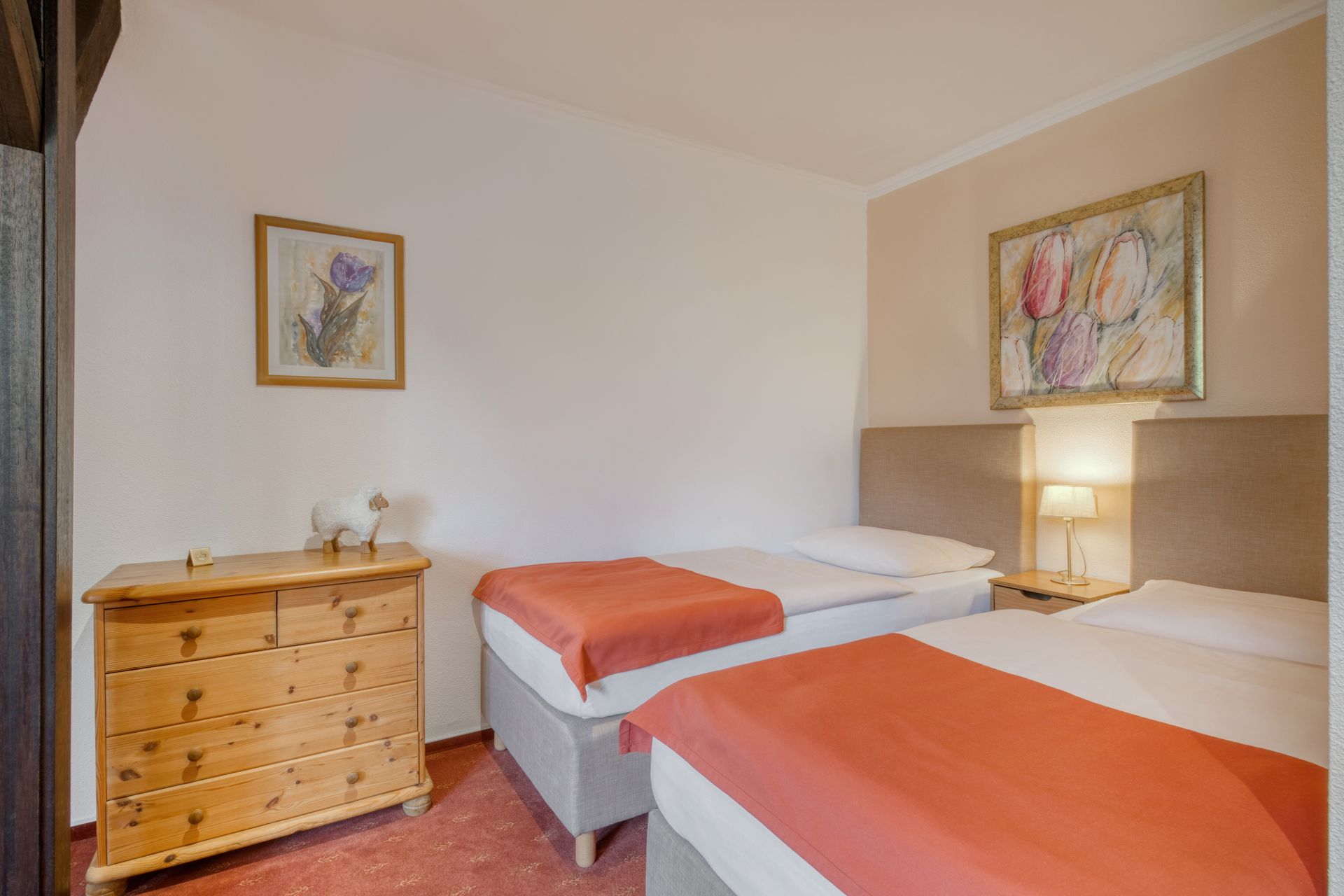 Ein Schlafzimmer mit zwei Betten, einer Kommode und einem Bild an der Wand.