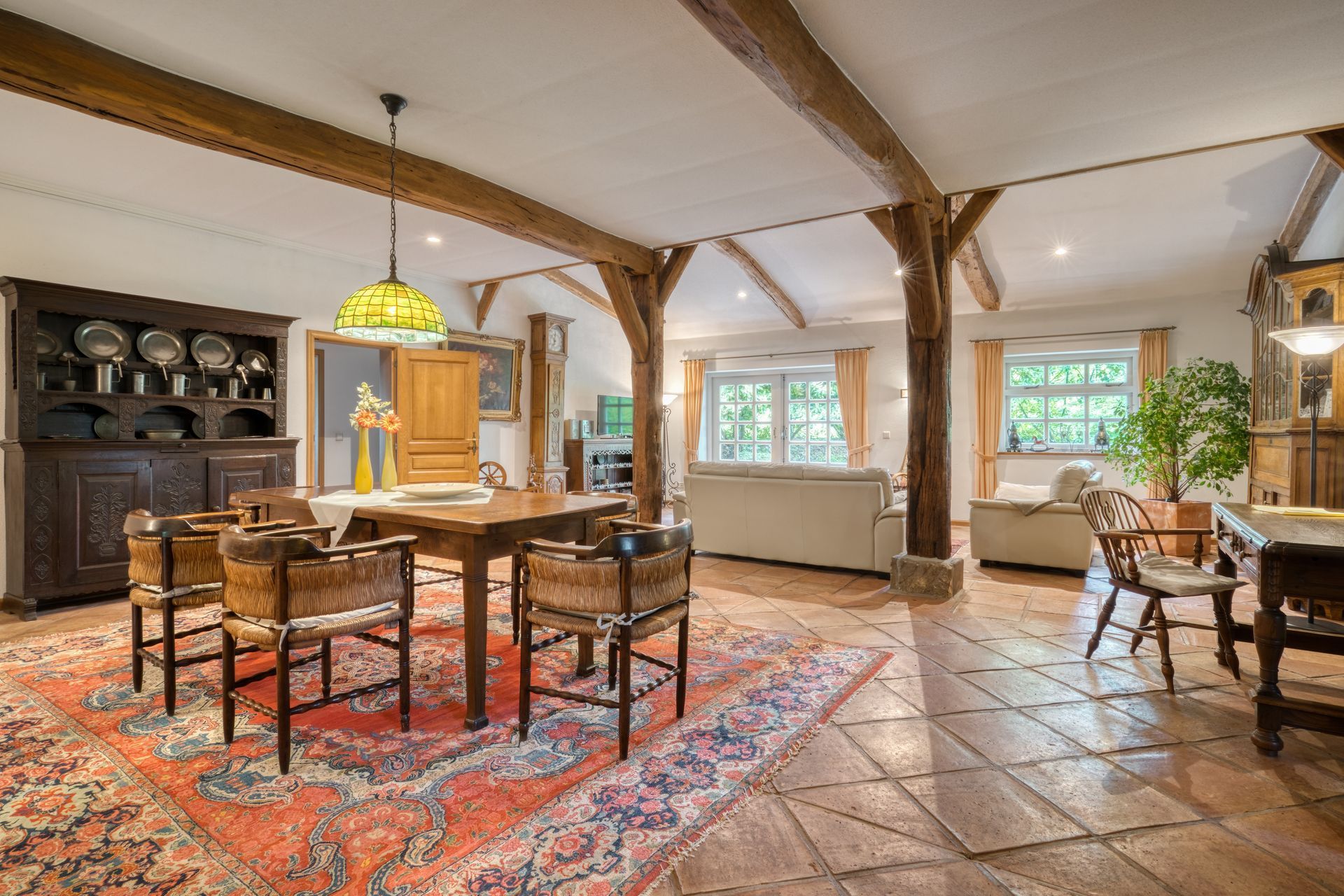 Ein großes Wohnzimmer mit Tisch, Stühlen und einem Teppich.