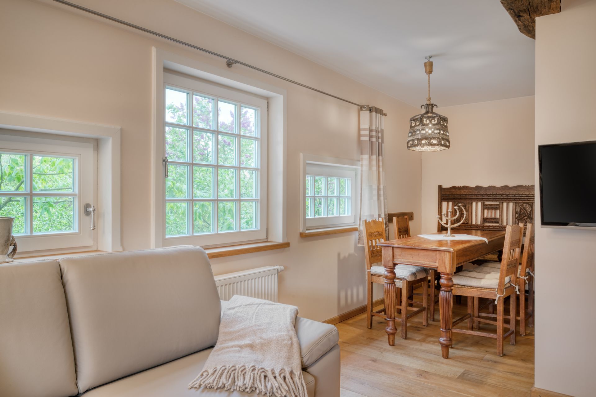 Ein Wohnzimmer mit Sofa, Tisch und Stühlen und einem Fernseher.