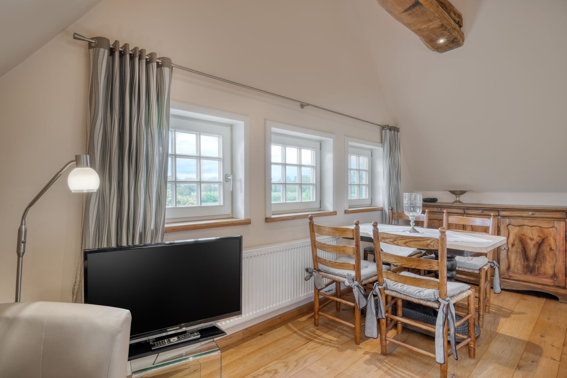 Ein Wohnzimmer mit Esstisch und Stühlen und einem Flachbildfernseher.