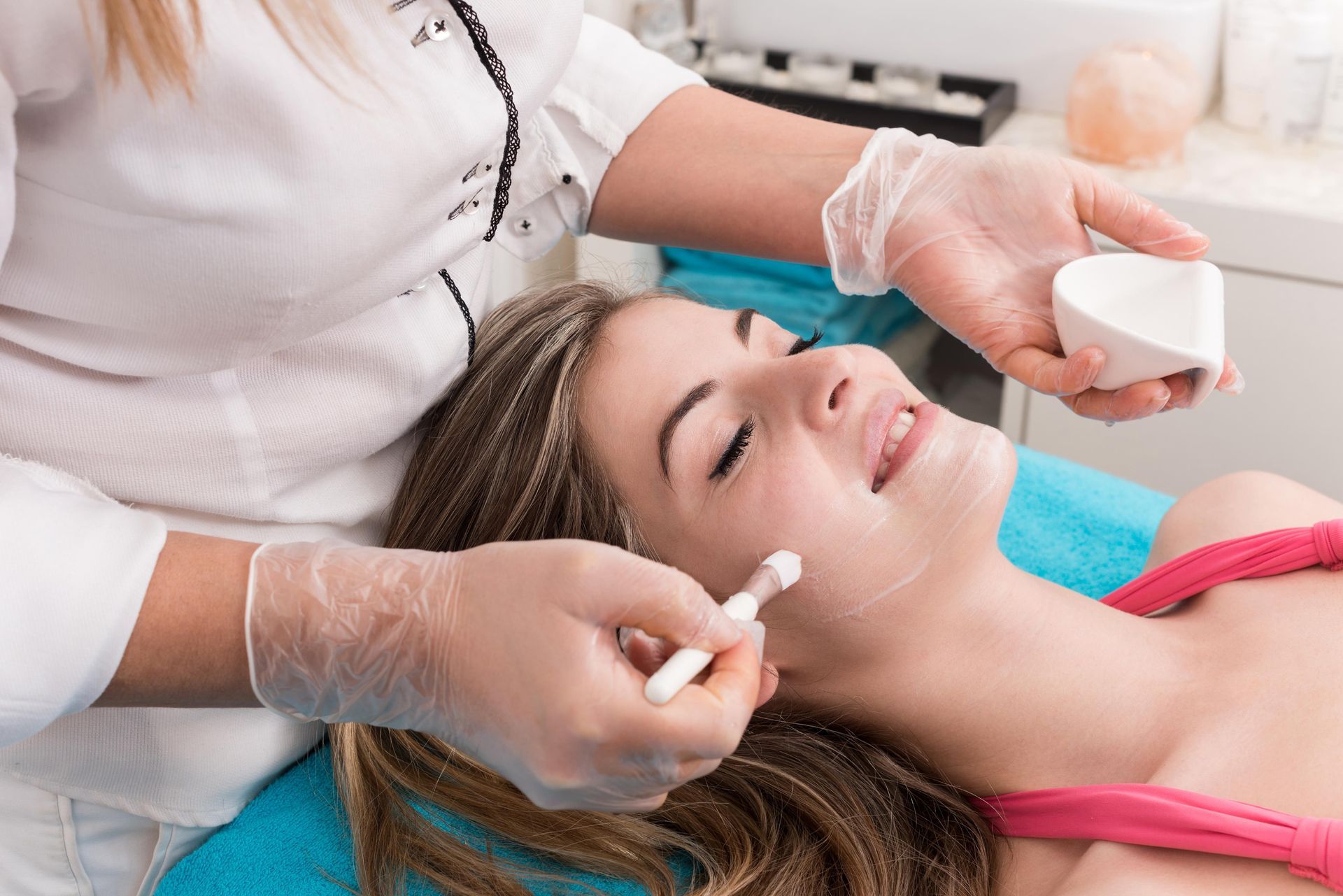A woman is getting a facial treatment at a beauty salon.