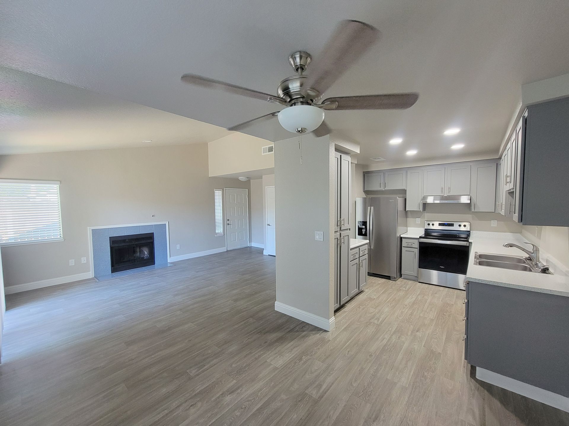 Laundry room with rows of white washing machines, a window, and a trash can.