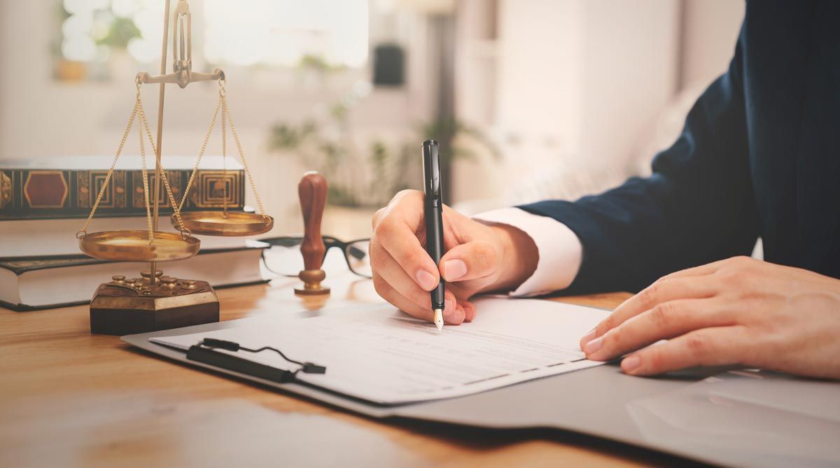 A person is writing on a piece of paper with a pen.