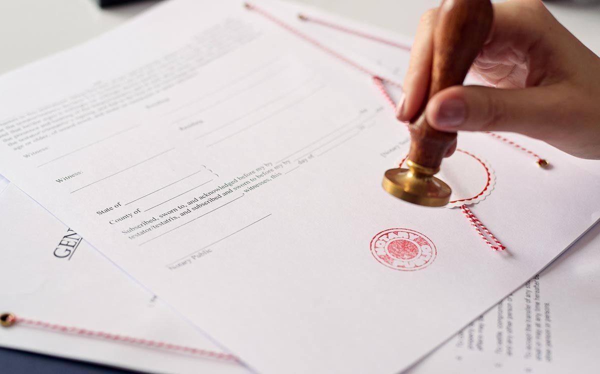 A person is stamping a document with a wax seal.
