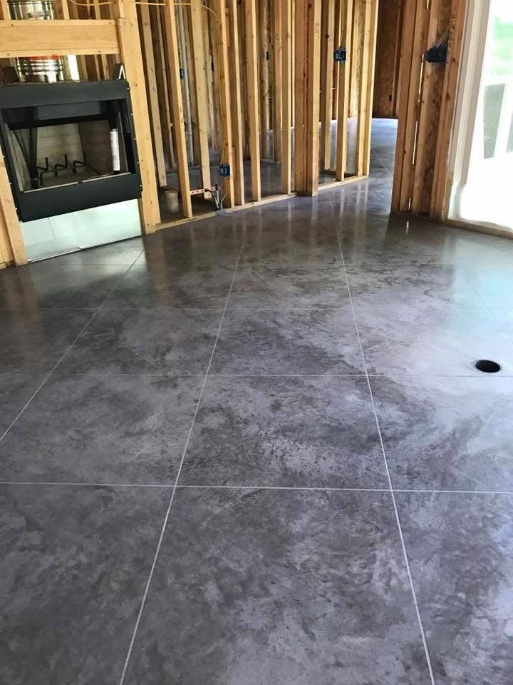 A living room with a fireplace and a concrete floor.