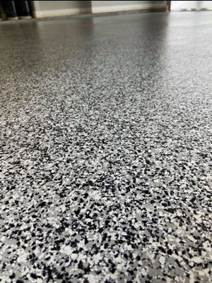A close up of a gray and black marble floor in a room.