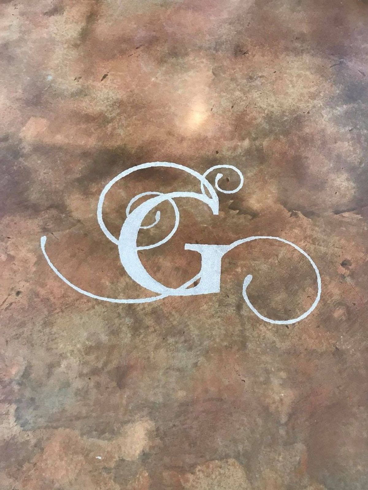A close up of a monogram on a concrete surface.