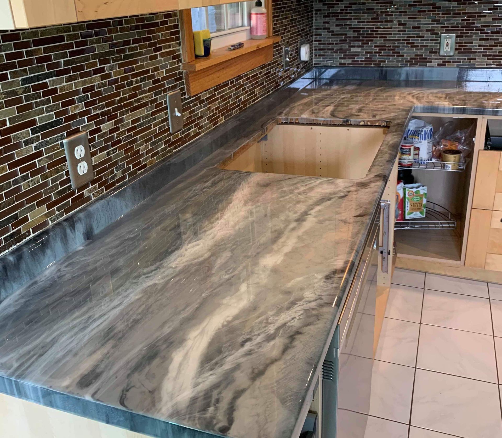 A kitchen with a marble counter top and a sink