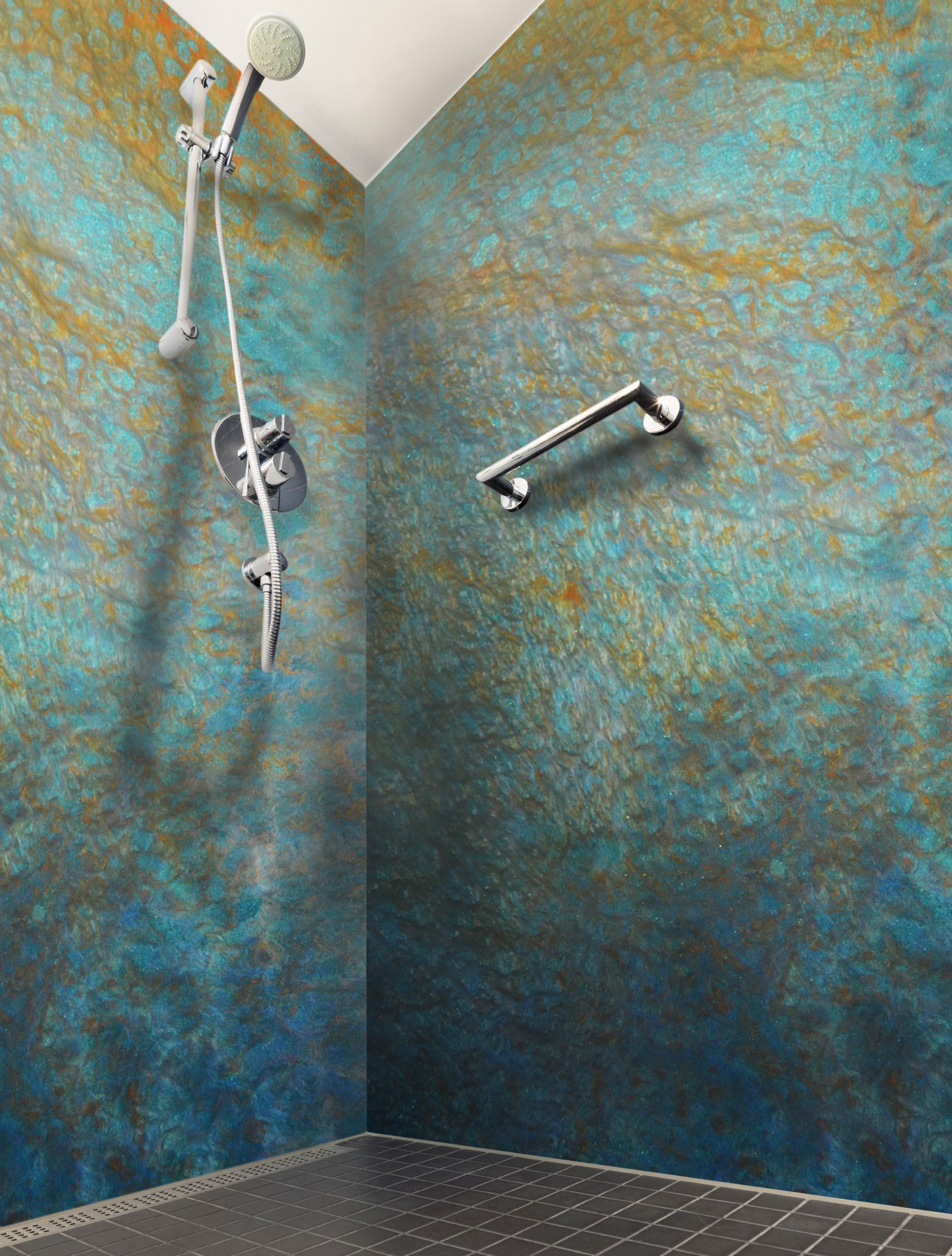 A shower with a blue wall and a shower head hanging from the ceiling.