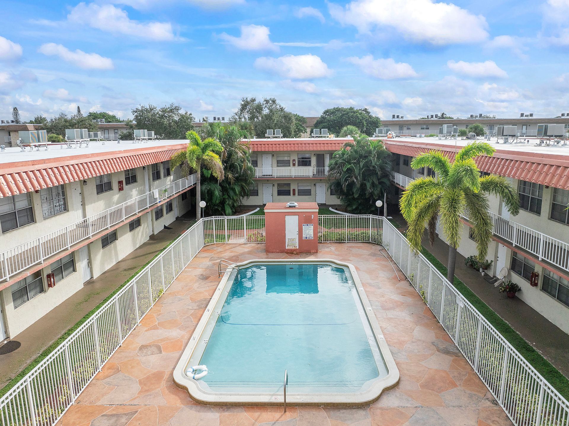 An aerial view of a large swimming pool surrounded by buildings.