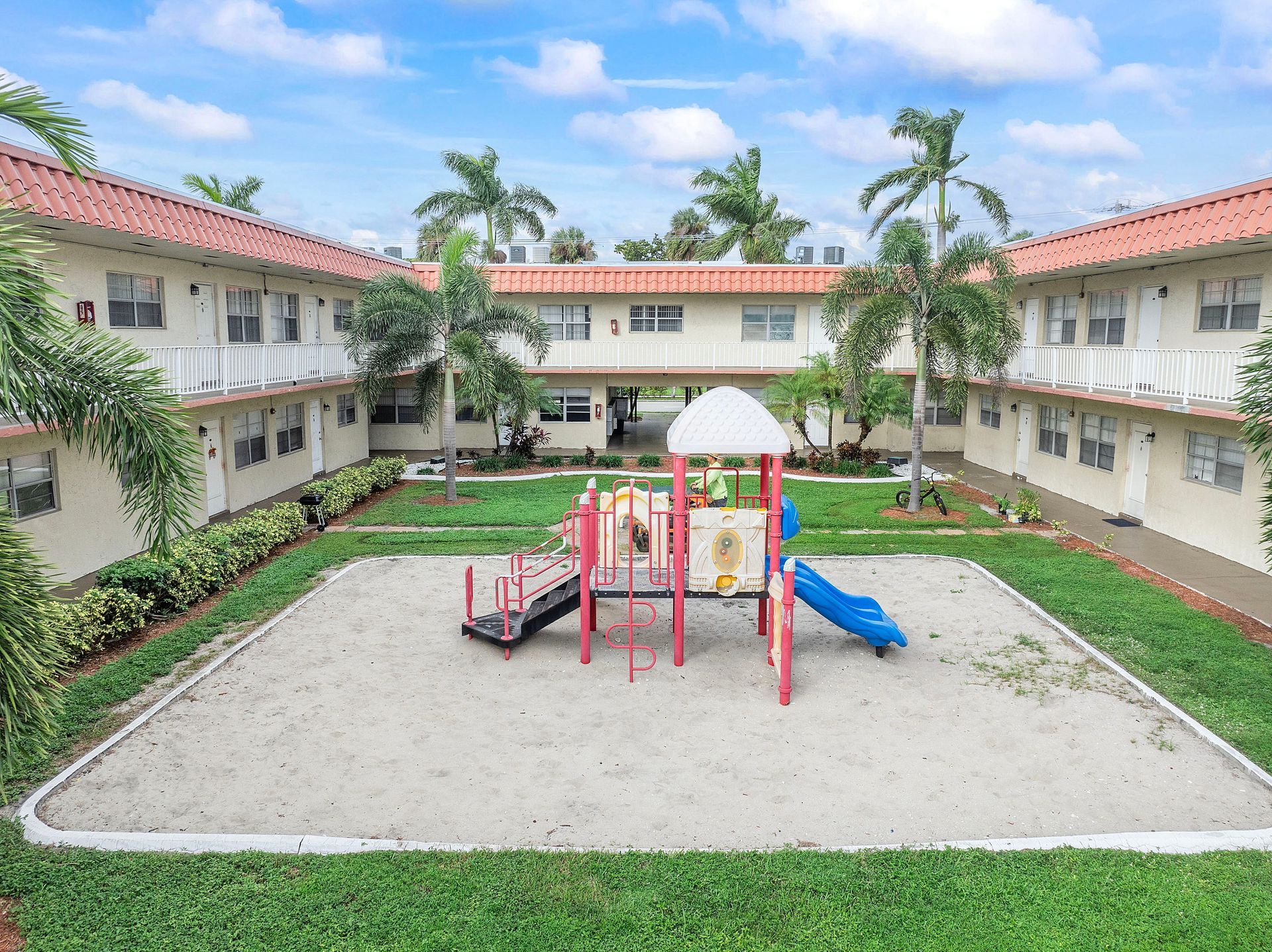 An aerial view of a playground in a courtyard surrounded by buildings.