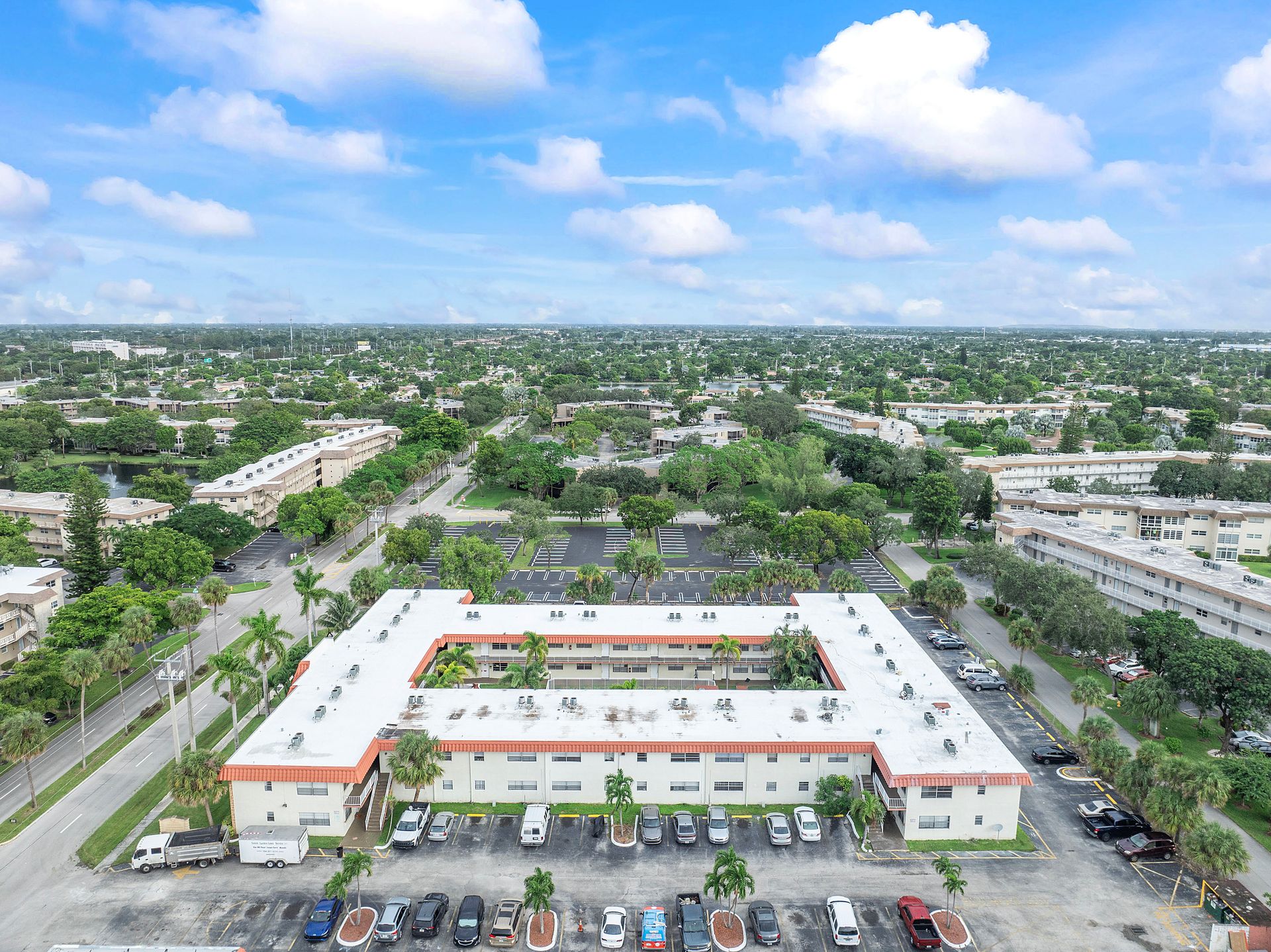An aerial view of a large building with a parking lot in front of it.
