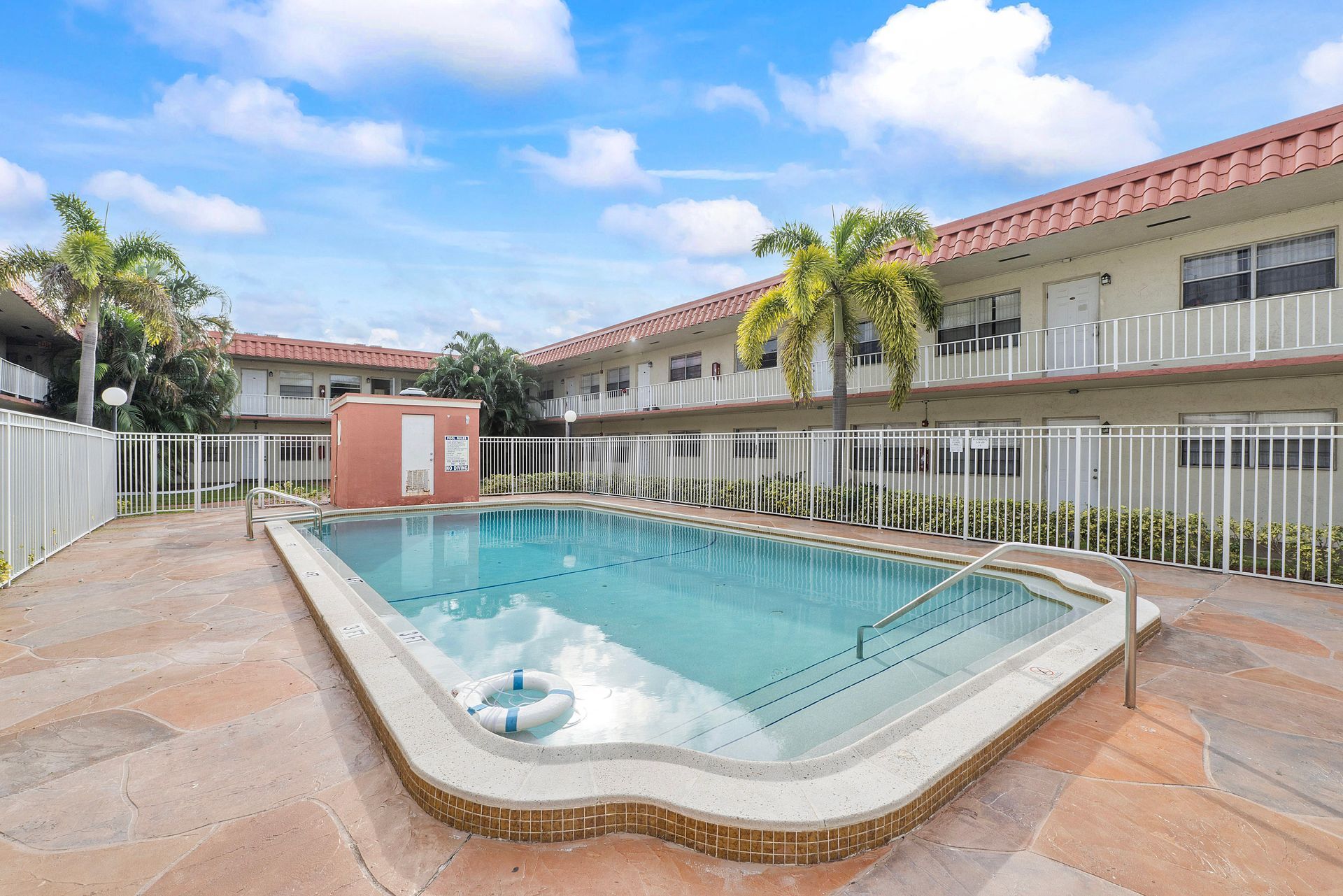 There is a large swimming pool in the middle of a building.