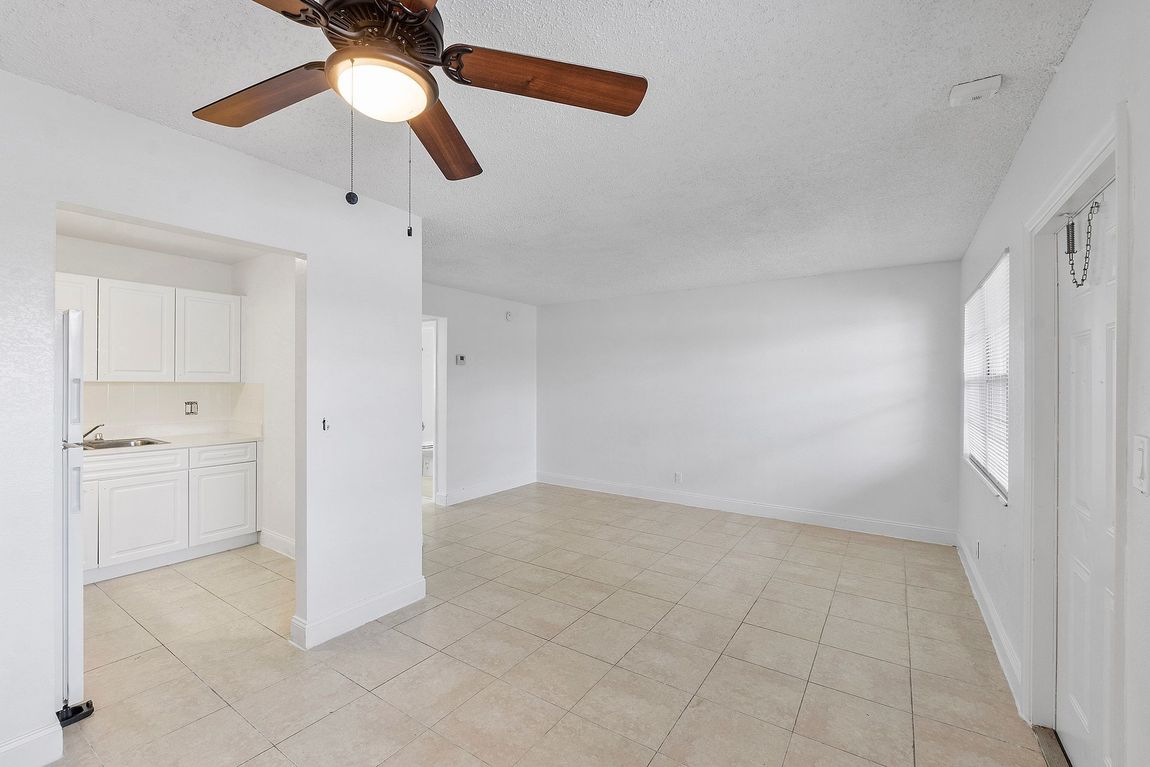 A living room with a ceiling fan and a window